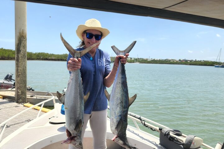 a person holding a fish on a boat in a body of water