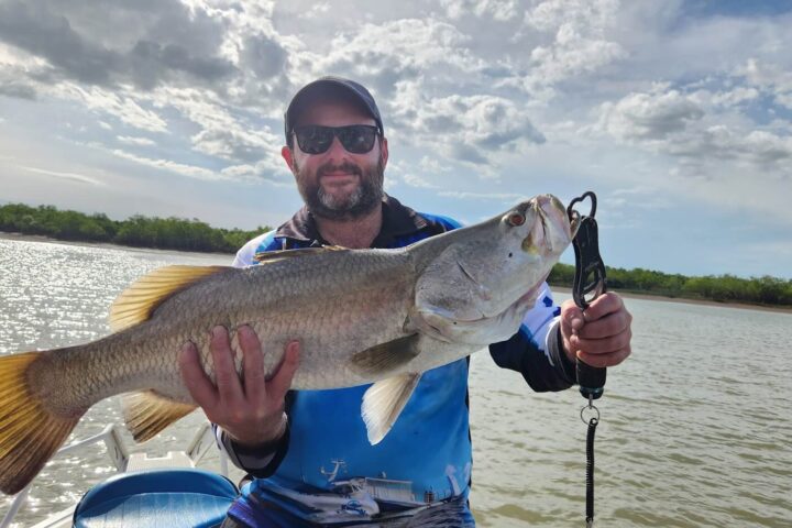 a man holding a fish swimming under water