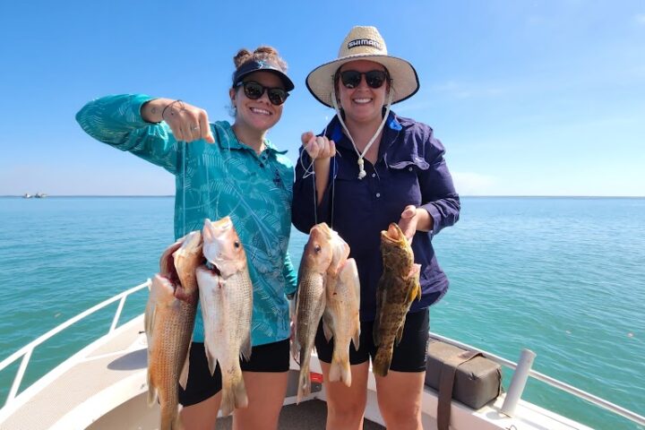 a person holding a fish on a boat in a body of water