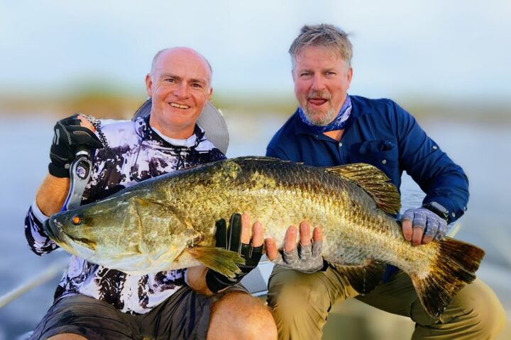 a man holding a fish in the water