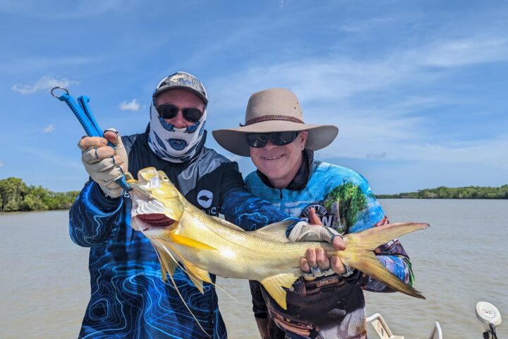 a person holding a fish on a boat in a body of water