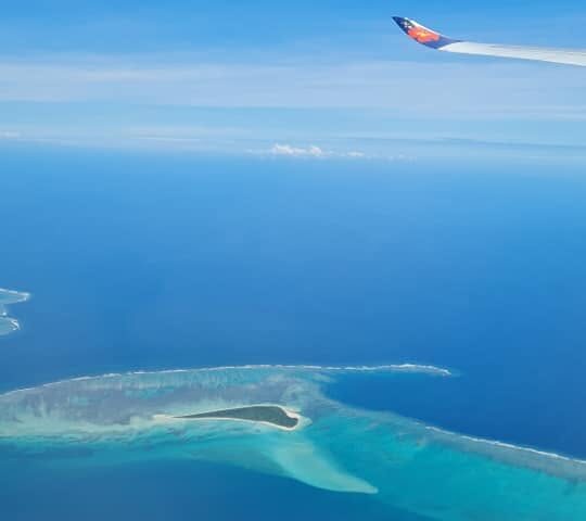 View from airplane window of islands and blue ocean.
